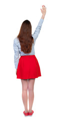 Fototapeta premium Back view of beautiful woman welcomes. Young teenager girl hand waving from. Rear view people collection. backside view of person. Isolated over white background. Long-haired brunette in red skirt