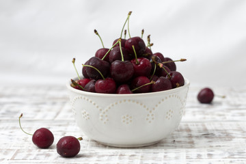 red cherries in a beautiful plate. light background