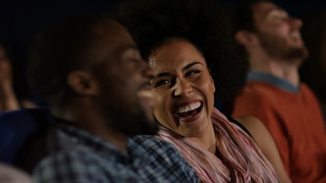  Couple watching a film in crowded movie theatre