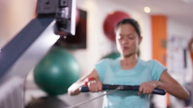  Woman working out on rowing machine at the gym
