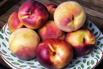 Plato con nectarinas sobre fondo negro