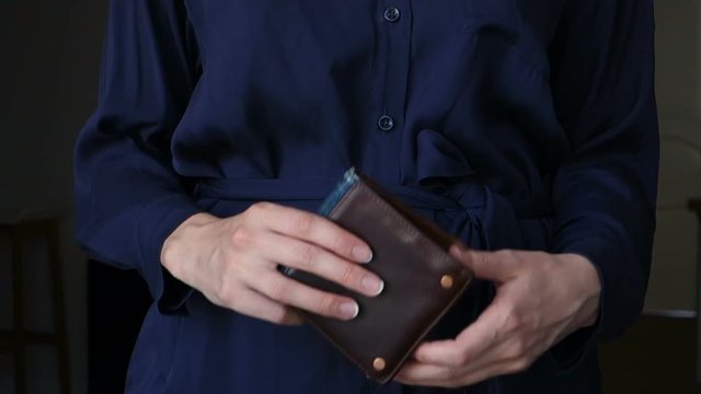 Woman counting dollars in her wallet