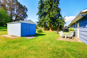 Naklejka premium Spacious back yard of blue house with small shed