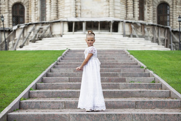 Fototapeta premium Portrait of a beautiful young little girl in white gown