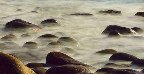 rocks in the sea close-up with blurred water.long exposure exposure. fog effect, haze among the...