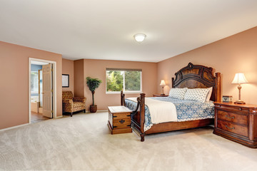 Bedroom interior with carved wooden furniture and carpet floor.