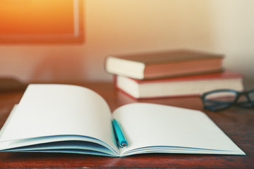 notebook with pen and books at workplace