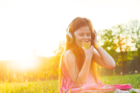 girl eating ice cream and listening to music in headphones