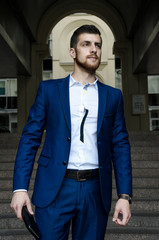 Handsome man in the jacket on a building background