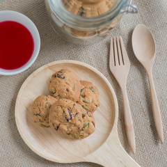 Oat cookies with pumpkin seeds and raisin on a wooden plate.