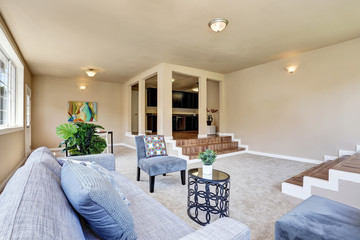 Hallway interior in beige walls. Living room with modern blue sofa
