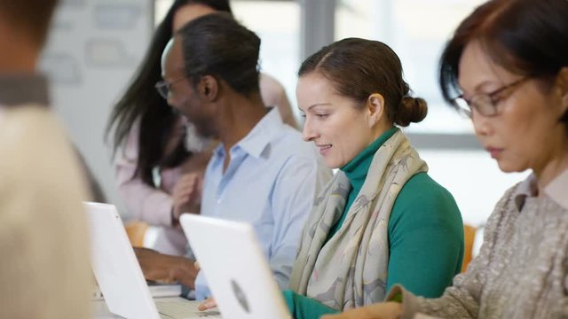  Group of mature students in adult education class, working on laptop computer