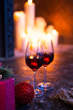 Two glass with red wine on Christmas tree and fireplace backgrou