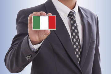 Businessman in suit hand holding a business card with Italy Flag