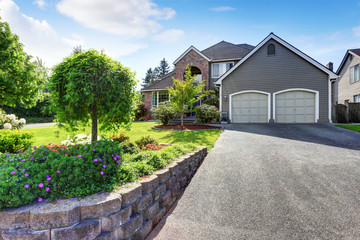 Luxury house exterior with brick and siding trim and double garage.