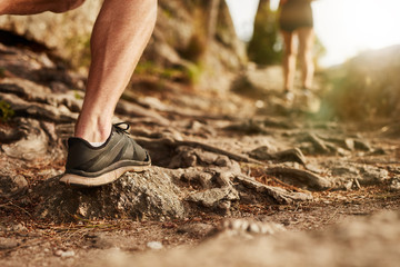 Man trail running on rocky terrain