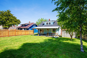 Obraz premium Backyard of blue American house with well kept lawn around