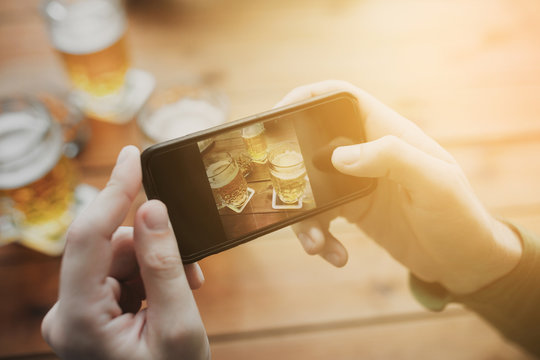 close up of hands with smartphone picturing beer