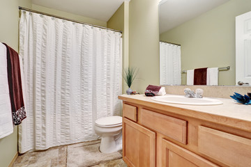 Fototapeta na wymiar Bathroom interior with vanity and white shower curtain.