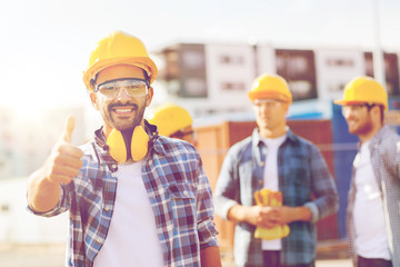 group of smiling builders in hardhats outdoors