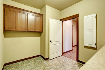 Empty bathroom interior with vanity cabinet and tile floor.