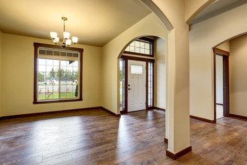 Hallway interior with columns, hardwood floor and white entry door