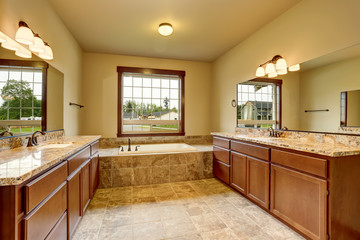 Luxury bathroom interior with granite trim and two vanity cabinets.