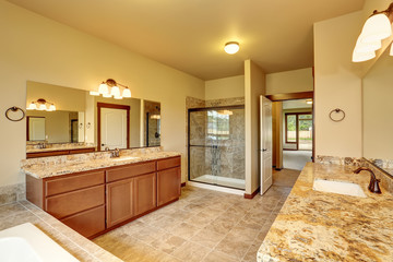 Luxury bathroom interior with granite trim and two vanity cabinets.