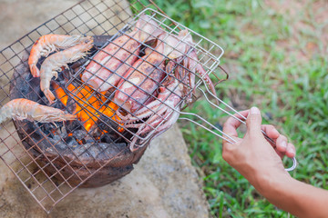 people grilled fresh squids on the grill over stove at home.