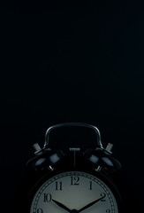 Time is up - alarm clock standing isolated on black background