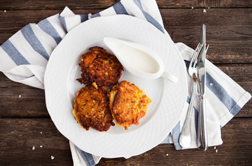 hash brown potato cakes with creamy sauce on a wooden background