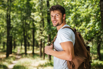 Man with backpack walking in forest