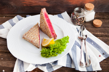 Red tuna steak with lemon on wood background