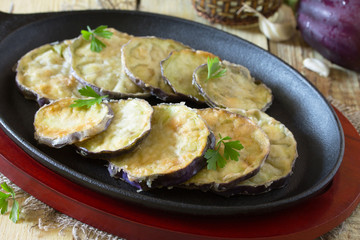 Fried eggplant on a cast iron skillet in a rustic style.