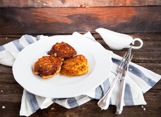 hash brown potato cakes with creamy sauce on a wooden background