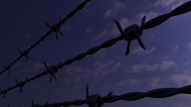 Parallel barbed wires against evening cloudy sky, loop able dolly clip. 4K