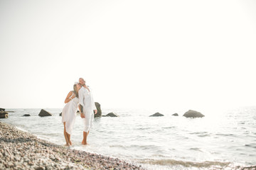 happy just married young wedding couple celebrating and have fun at beautiful beach sunset