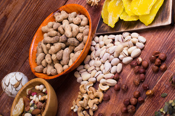 Fototapeta na wymiar Nuts and dry fruit, in plates, on boards
