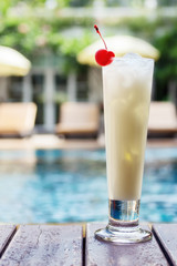 Pina colada cocktail beside swimming pool
