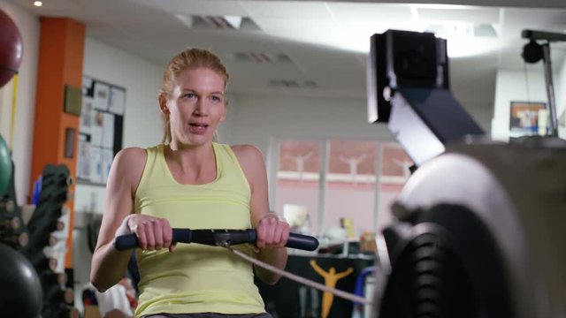  Woman working out on rowing machine at the gym