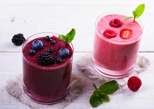 Summer berries smoothie  on white wooden background