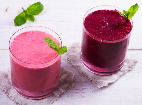 Summer berries smoothie  on white wooden background