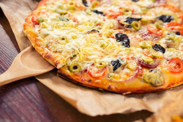 man takes a slice of hot freshly baked pizza with a lot of cheese Parmesan