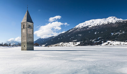 Winter scene at Lake Reschen with sunken gray steeple