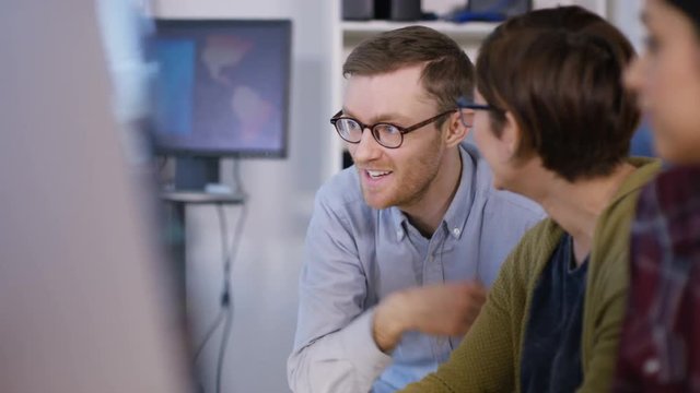  Young computer experts working in office with lots of computers