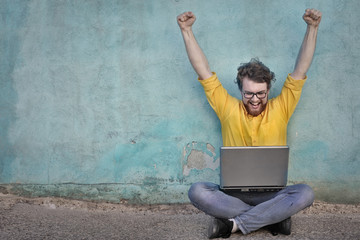 Jubilant man using a laptop