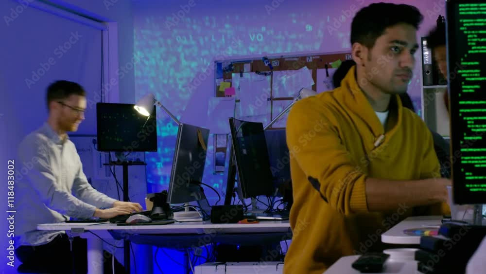 Wall mural time lapse of young computer experts working in office with lots of computers