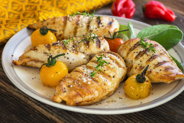 Barbecue grilled chicken breasts on wooden background