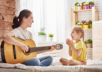 Mother and daughter playing guitar