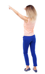 Back view of  pointing woman. beautiful girl. Rear view people collection.  backside view of person.  Isolated over white background. Blonde in blue pants I saw something in the distance.